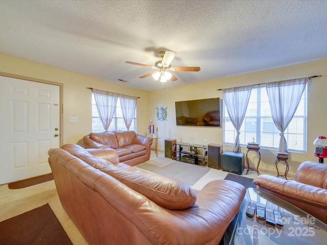 carpeted living room with a textured ceiling and ceiling fan