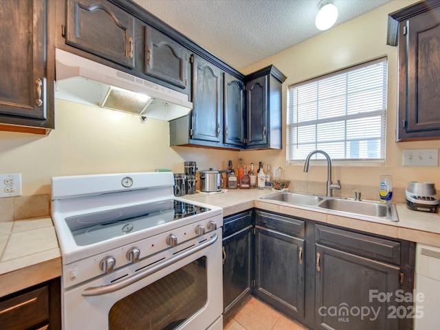 kitchen with sink, white electric range oven, a textured ceiling, light tile patterned floors, and dark brown cabinets