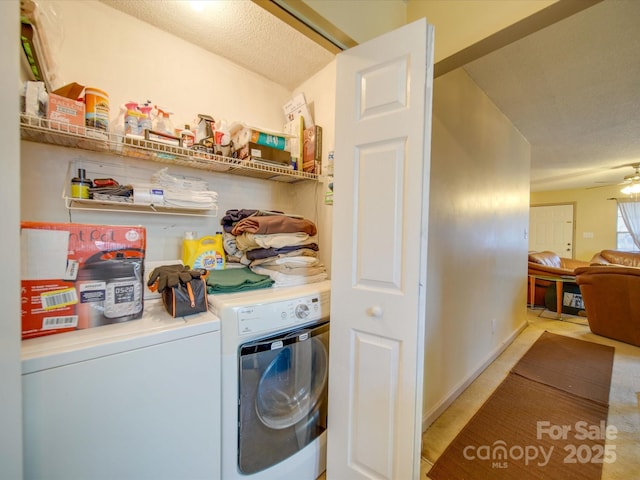 laundry area with ceiling fan, washer and clothes dryer, and a textured ceiling