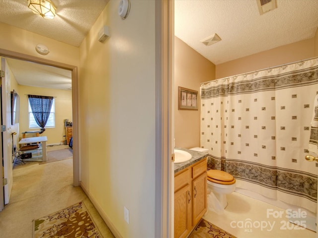 bathroom with a textured ceiling, toilet, and vanity