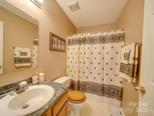 bathroom featuring a textured ceiling, toilet, vanity, and walk in shower