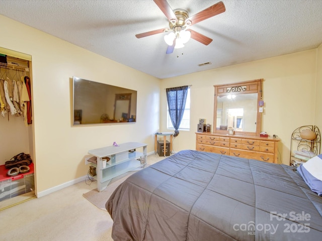 bedroom featuring a textured ceiling, ceiling fan, carpet flooring, and a closet