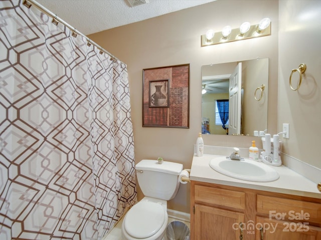 bathroom featuring ceiling fan, a textured ceiling, toilet, and vanity