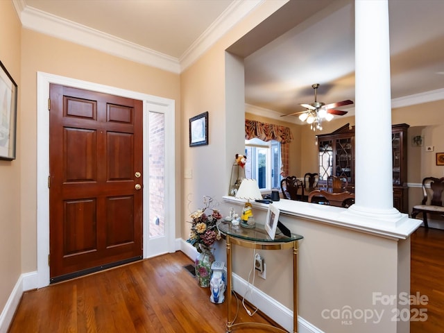 entryway with decorative columns, dark hardwood / wood-style floors, crown molding, and ceiling fan