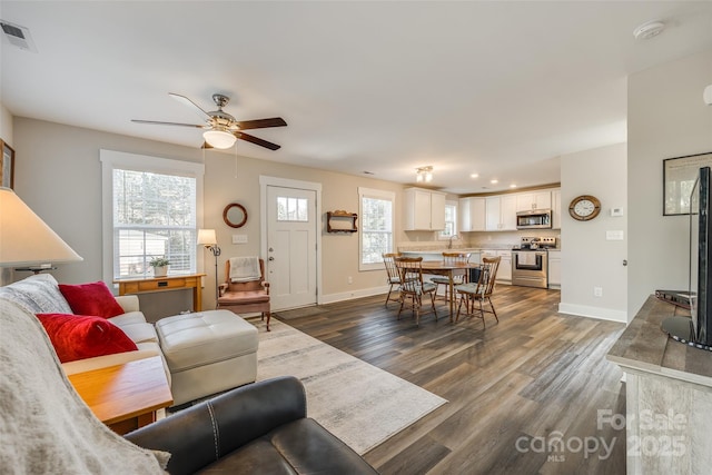 living room with ceiling fan, dark wood-type flooring, and sink