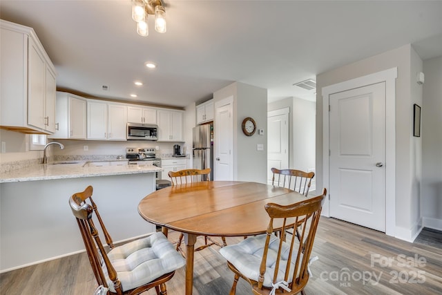 dining room featuring sink and light hardwood / wood-style floors