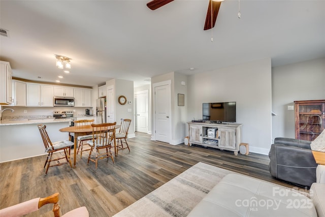 dining room featuring ceiling fan, dark wood-type flooring, and sink