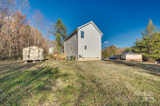 rear view of property featuring a deck, a shed, cooling unit, and a yard