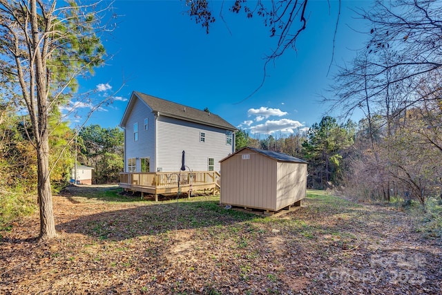 back of property with a wooden deck and a storage shed