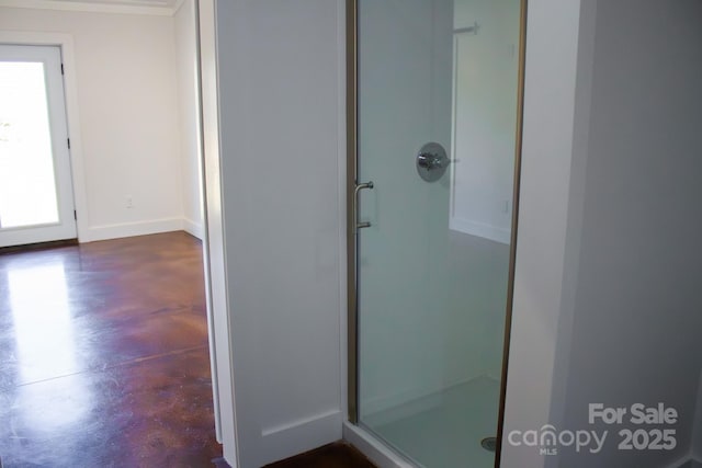 bathroom featuring a shower with shower door and concrete flooring