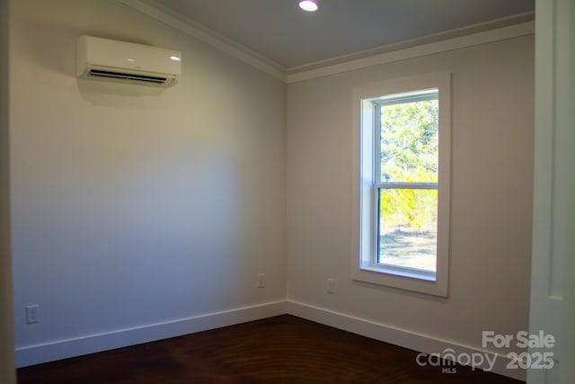 spare room with a wall unit AC, a wealth of natural light, ornamental molding, and dark hardwood / wood-style flooring