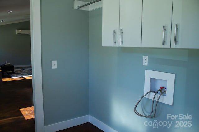 clothes washing area featuring washer hookup, cabinets, and a wall mounted air conditioner