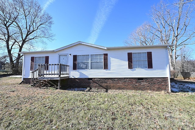 manufactured / mobile home with a wooden deck and a front yard