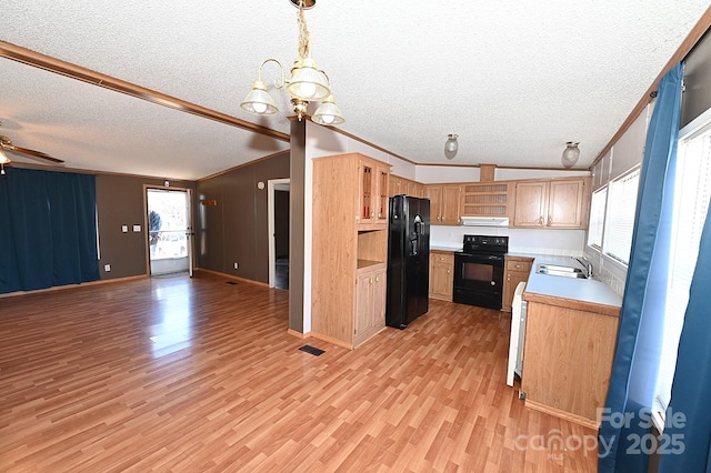 kitchen with black appliances, a textured ceiling, vaulted ceiling, pendant lighting, and sink