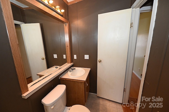 bathroom with toilet, tile patterned floors, and vanity