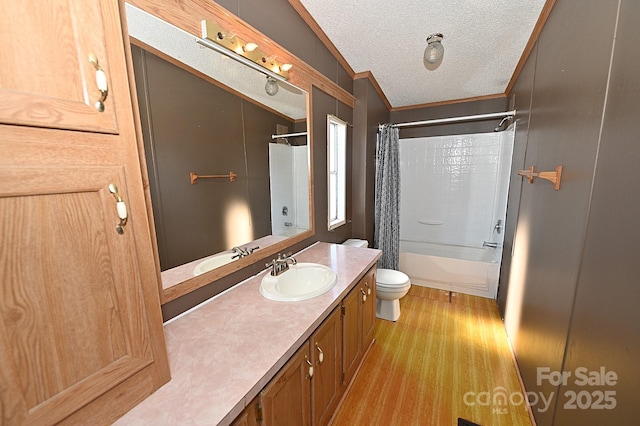 full bathroom with toilet, shower / bath combination with curtain, wood-type flooring, a textured ceiling, and vanity