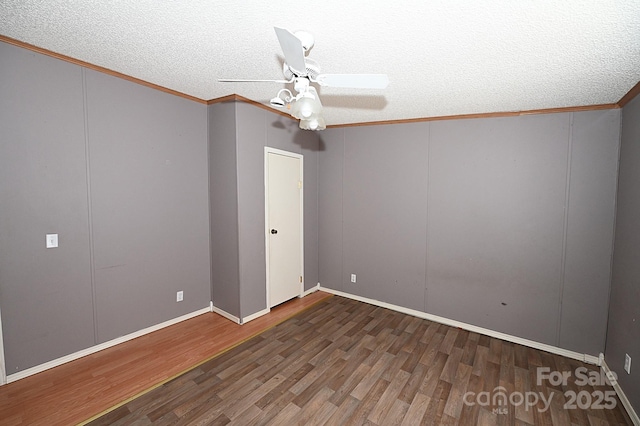 unfurnished room with a textured ceiling, ceiling fan, dark hardwood / wood-style flooring, and crown molding