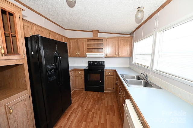 kitchen featuring black appliances, light wood-type flooring, a textured ceiling, crown molding, and sink