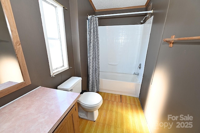 full bathroom featuring toilet, a textured ceiling, shower / bath combination with curtain, and vanity