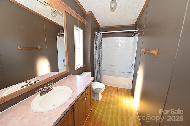 full bathroom featuring toilet, hardwood / wood-style floors, shower / bath combo with shower curtain, a textured ceiling, and ornamental molding