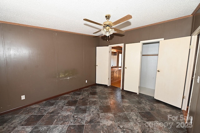 unfurnished bedroom with ceiling fan, connected bathroom, crown molding, and a textured ceiling