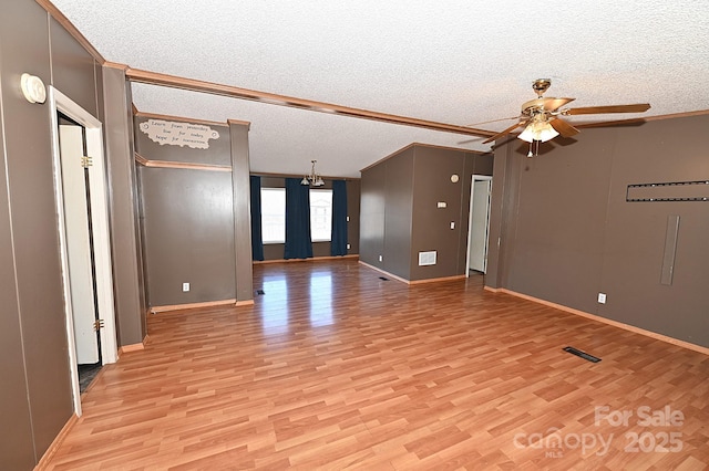 unfurnished room featuring ceiling fan with notable chandelier, a textured ceiling, and light hardwood / wood-style floors