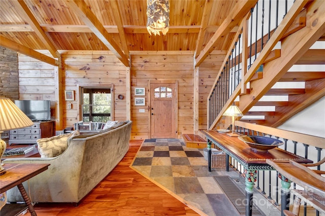 living room with hardwood / wood-style floors, wood ceiling, beamed ceiling, wood walls, and a chandelier