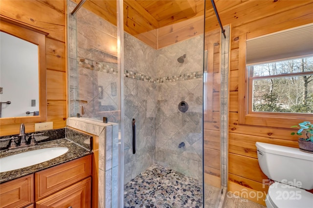 bathroom featuring toilet, a shower with door, and wood walls