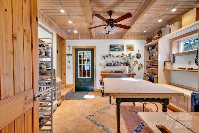 interior space featuring ceiling fan, wood ceiling, and beamed ceiling