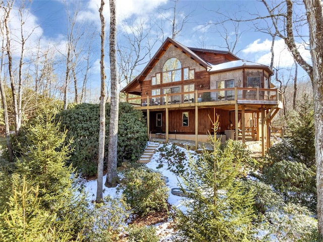 rear view of property with a wooden deck and a sunroom