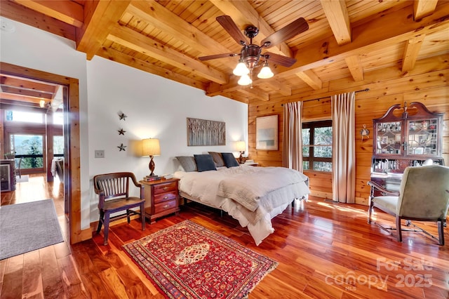 bedroom featuring ceiling fan, wood-type flooring, wood walls, and wooden ceiling