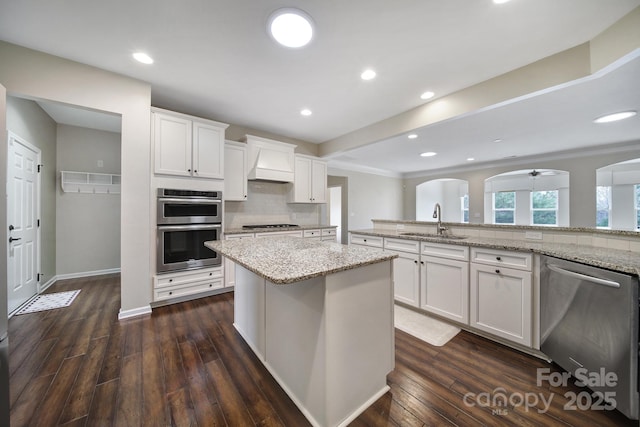 kitchen featuring light stone counters, sink, white cabinets, and appliances with stainless steel finishes