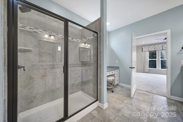 bathroom with a shower with shower door, vanity, ceiling fan, and tile patterned flooring