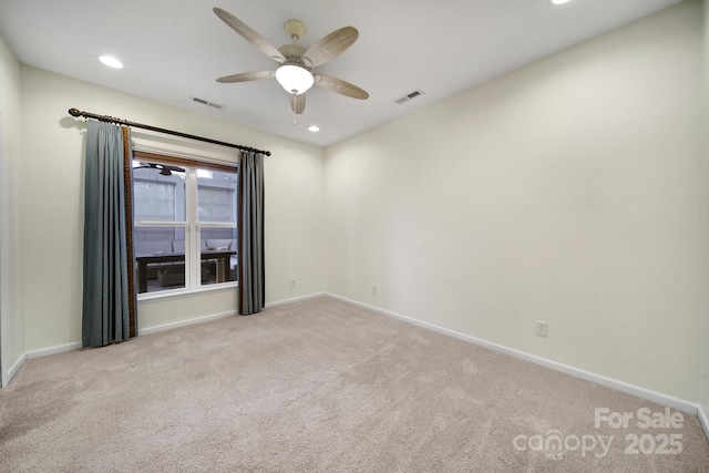 spare room with ceiling fan and light colored carpet