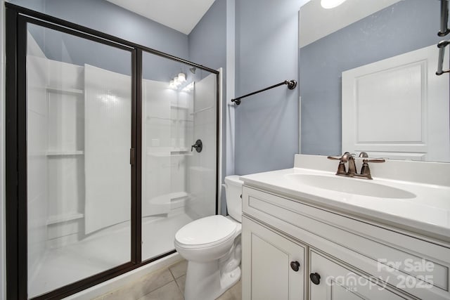 bathroom featuring toilet, walk in shower, vanity, and tile patterned flooring