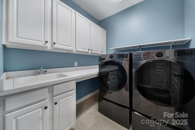 clothes washing area with cabinets, sink, independent washer and dryer, and light tile patterned flooring