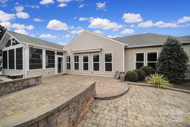 back of property with a sunroom and a patio