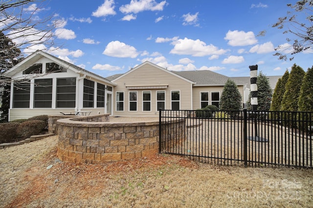 rear view of house with a patio area and a sunroom