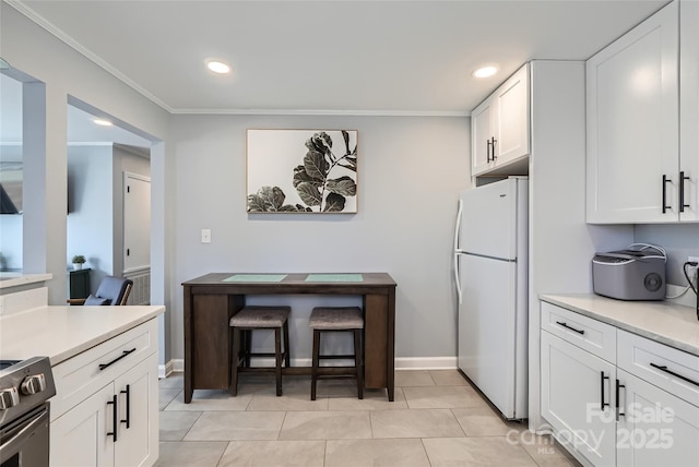 kitchen with crown molding, stainless steel range with electric stovetop, light tile patterned floors, white fridge, and white cabinets