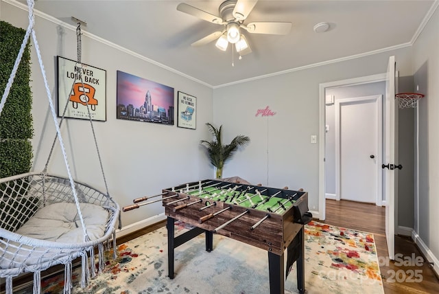 game room featuring ceiling fan, ornamental molding, and wood-type flooring