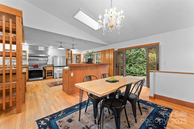 dining area featuring lofted ceiling, light hardwood / wood-style floors, and an inviting chandelier