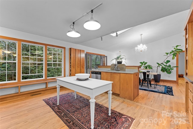 interior space featuring lofted ceiling, sink, a chandelier, light hardwood / wood-style floors, and track lighting