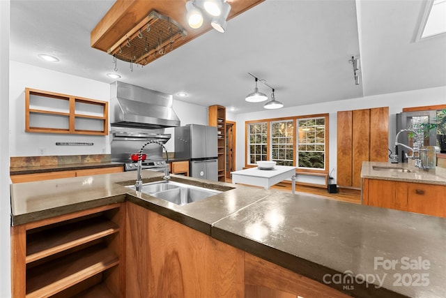 kitchen with extractor fan, sink, track lighting, and stainless steel fridge