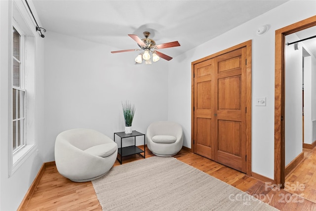 living area with ceiling fan and light wood-type flooring