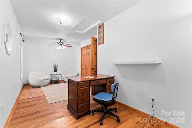 home office featuring ceiling fan, a textured ceiling, and light wood-type flooring