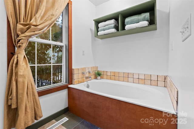 bathroom with a bathtub and tile patterned floors