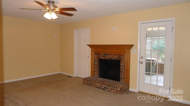 unfurnished living room with a textured ceiling, ceiling fan, carpet floors, and a brick fireplace