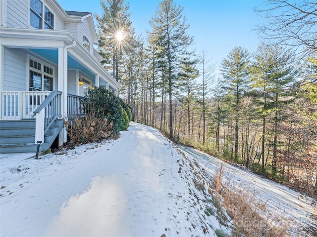 snow covered property with covered porch