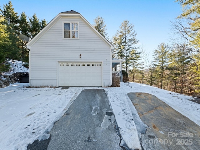 view of snow covered exterior featuring a garage