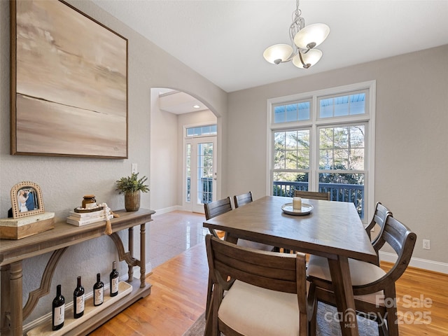 dining area with wood-type flooring and a notable chandelier